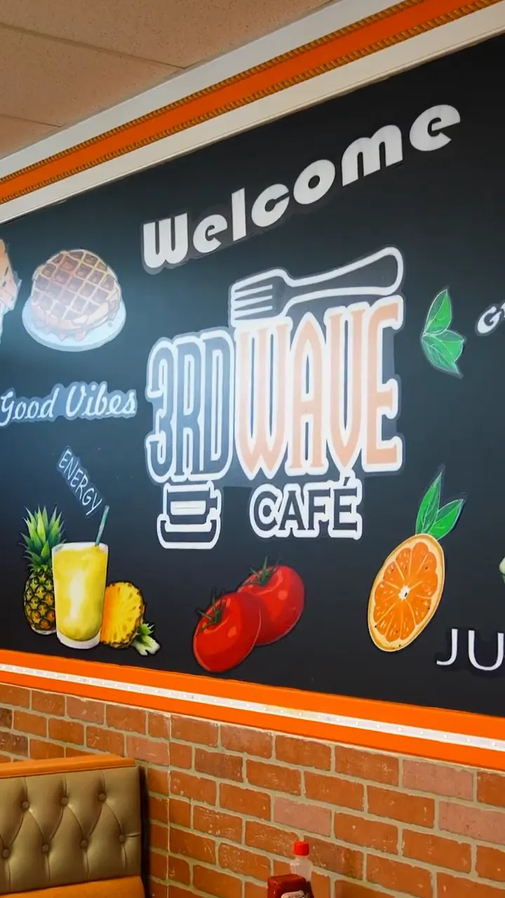 Inside 3rd Wave Cafe: the Welcome mural, orange chairs and the juice bar